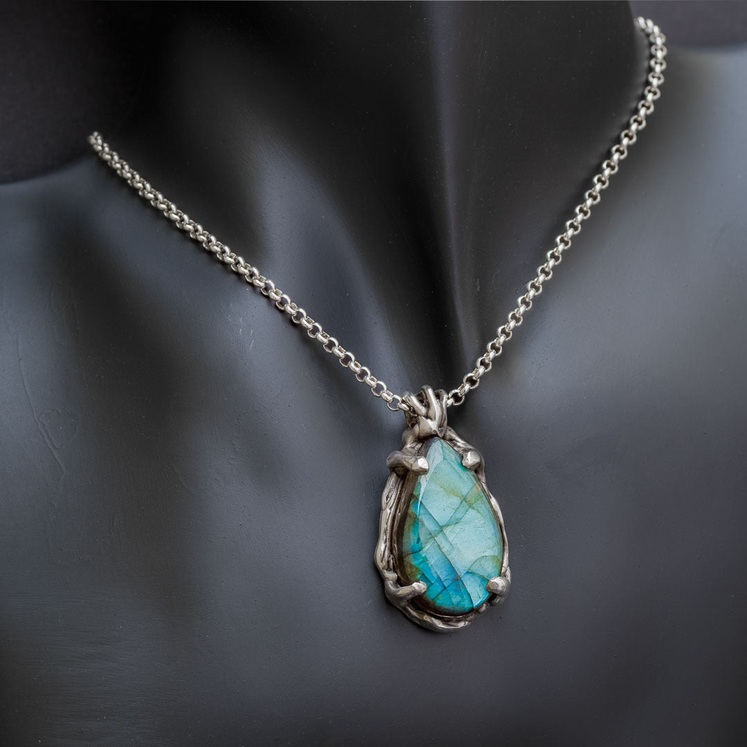 A southwestern style necklace with rainbow labradorite. The labradorite necklace has a frame of stars and is suspended from a sterling silver chain. 