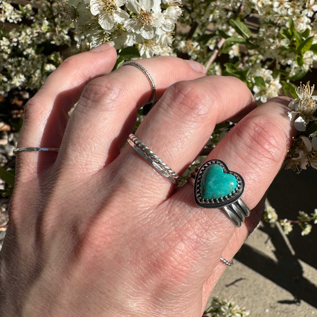 Detailed view of rich ocean blue Sonora turquoise heart with intricate silver bezel work, size 9.5