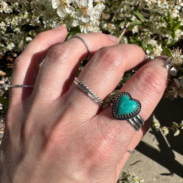 Detailed view of rich ocean blue Sonora turquoise heart with intricate silver bezel work, size 9.5