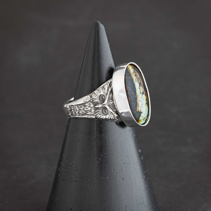 Close-up detail of sterling silver owl design with intricate blackened texture on handcrafted ring. Artisan crafted heirloom ring in Fort Collins, Colorado.