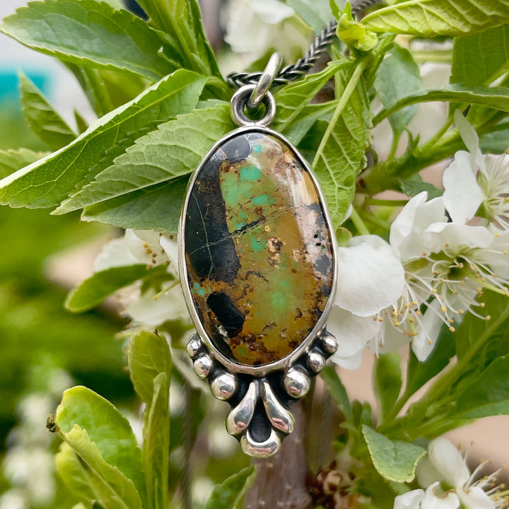 Blackjack turquoise pendant necklace in sterling silver with a decorative silver border. Handmade in Fort Collins, Colorado.
