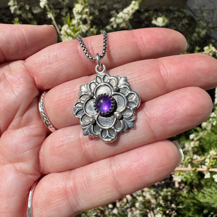 Artisan crafted sterling silver flower pendant with bezel-set amethyst cabochon. Perfect gift for Mother's Day.