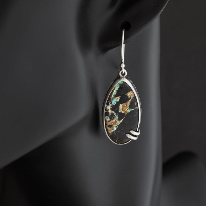 Artisan sterling silver earrings with Blackjack turquoise, shown on a black mannequin to demonstrate earring length and profile.
