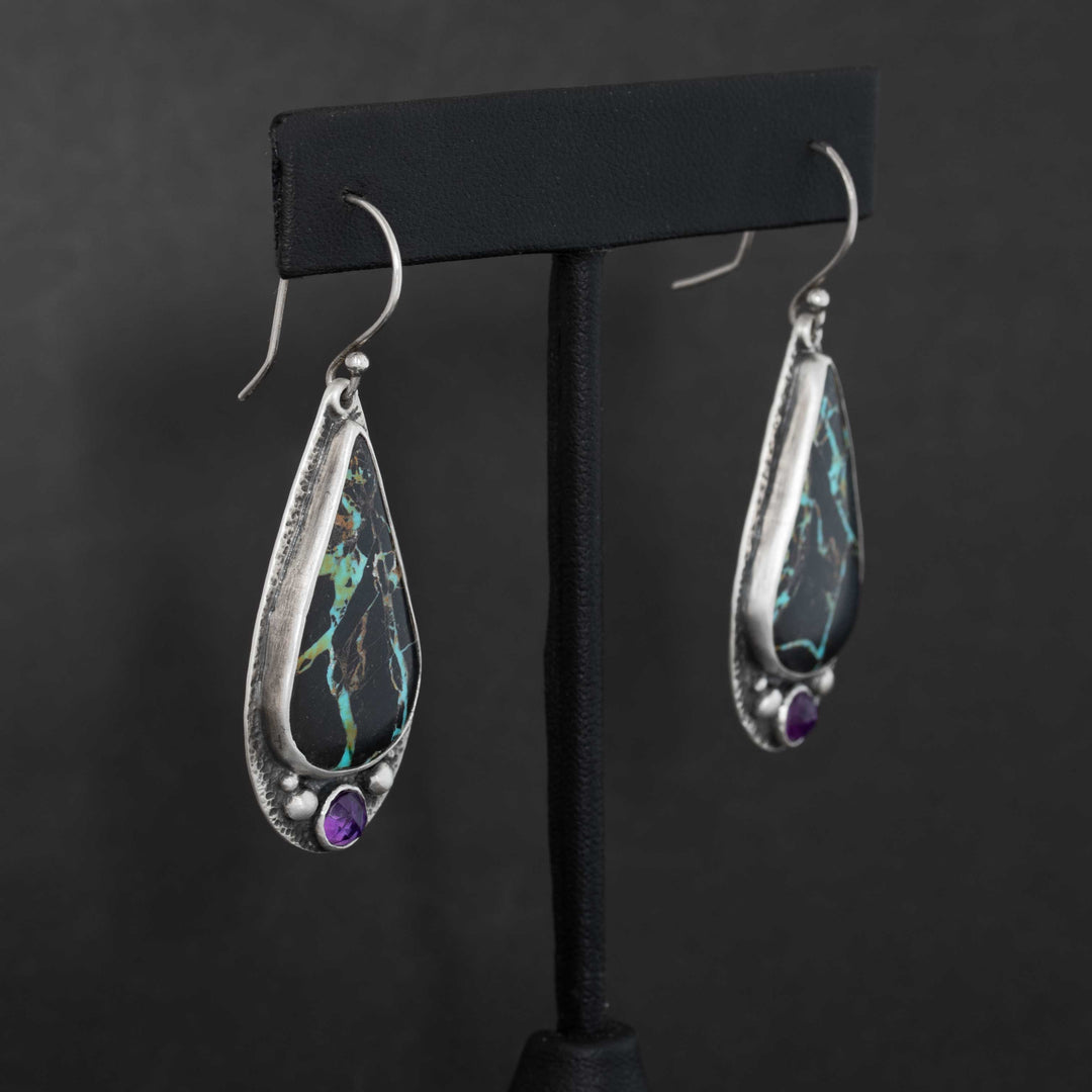 Side view of Blackjack turquoise drop earrings with rose cut amethyst accents in handmade sterling silver