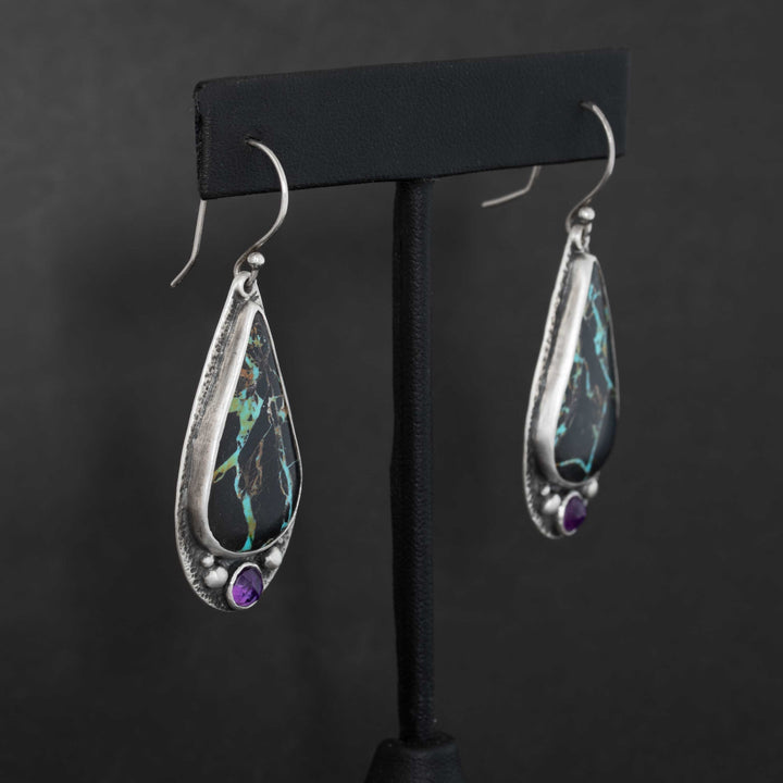 Side view of Blackjack turquoise drop earrings with rose cut amethyst accents in handmade sterling silver