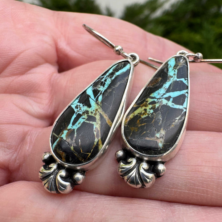 Detail of sterling silver scroll and granule base on Blackjack turquoise dangle earrings, oxidized finish, handmade in Colorado

