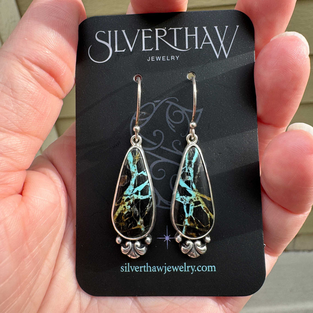 Blackjack turquoise teardrop drop earrings on Silverthaw Jewelry earring card, sterling silver with scroll detail, vivid teal matrix in dark chert