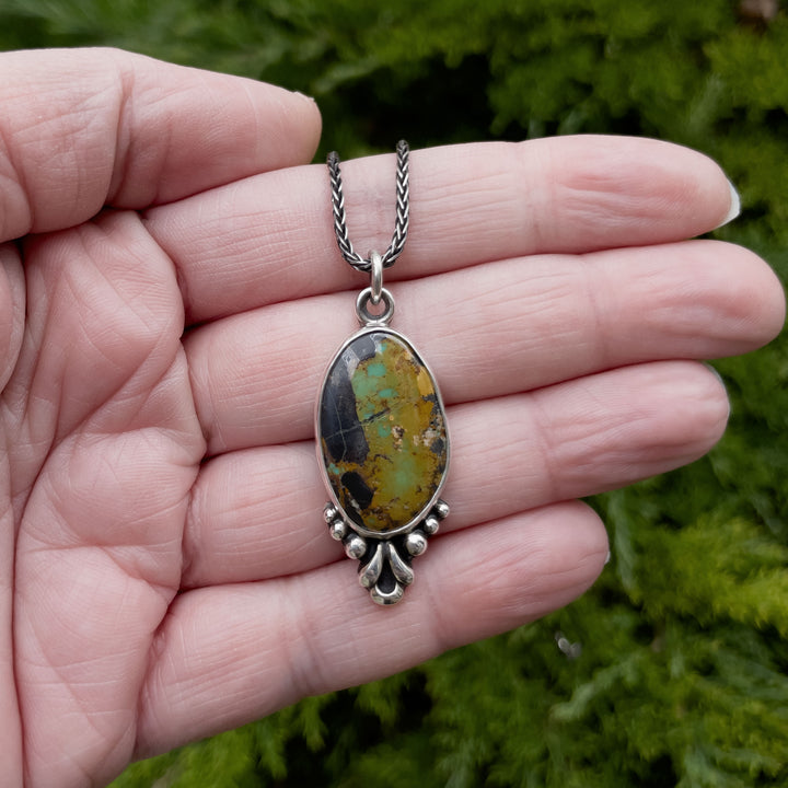 Blackjack turquoise pendant necklace photographed in natural light with Earthy green, gold, and black stone pattern. Handmade in Fort Collins, Colorado.