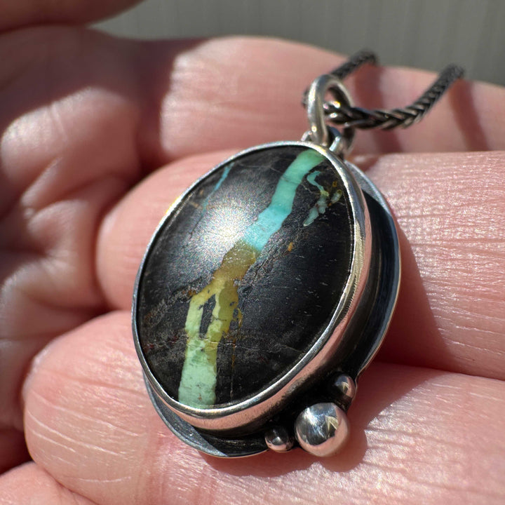 Side view of Blackjack turquoise pendant necklace showing bezel depth and gallery construction, oxidized sterling silver, artisan silversmith Colorado