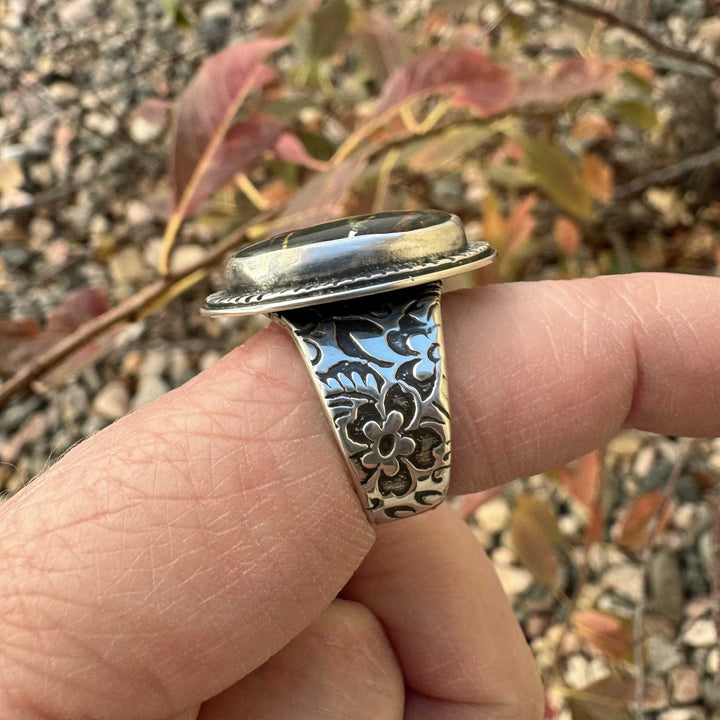 Close-up of the floral silver band and raised bezel setting on Blackjack turquoise ring.