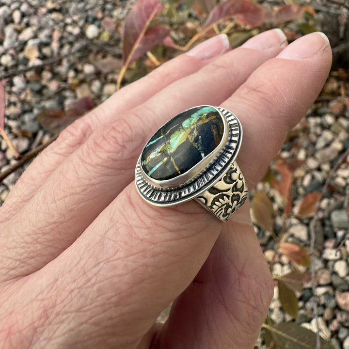 Angled view of handcrafted Blackjack turquoise ring with radiant turquoise webbing and floral band.
