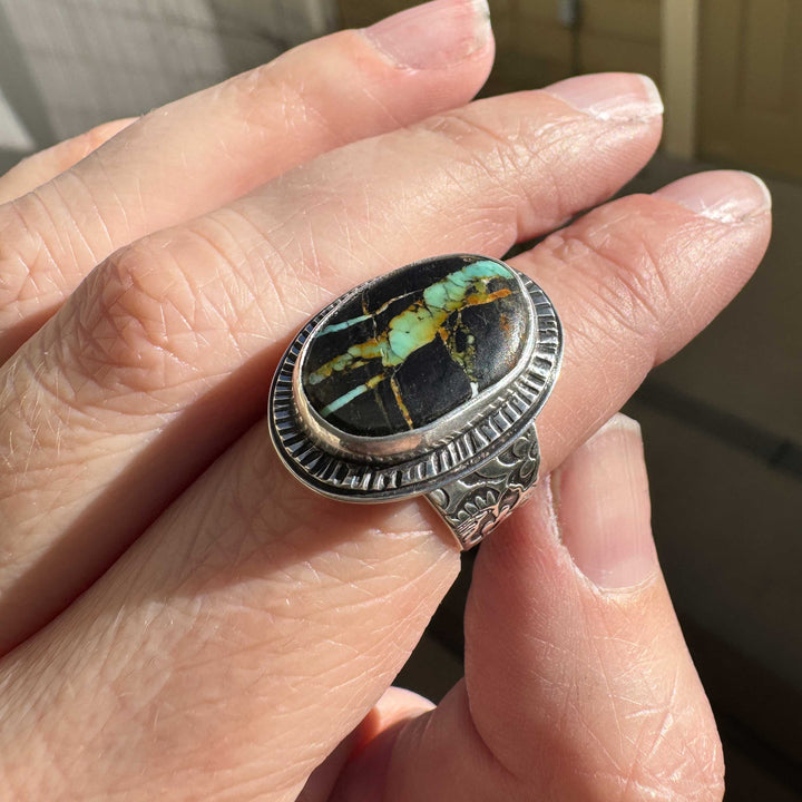 Handmade Blackjack turquoise ring photographed in natural sunlight, highlighting the stone’s golden and teal tones.