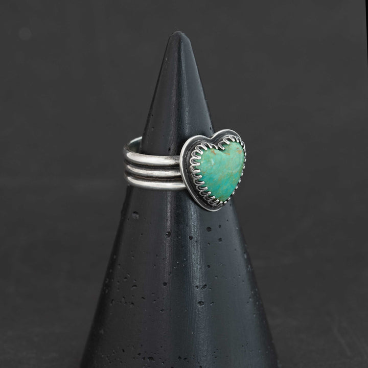 Sterling silver ring featuring blue-green Sonora turquoise heart with natural rust matrix, shown at angle, size 7