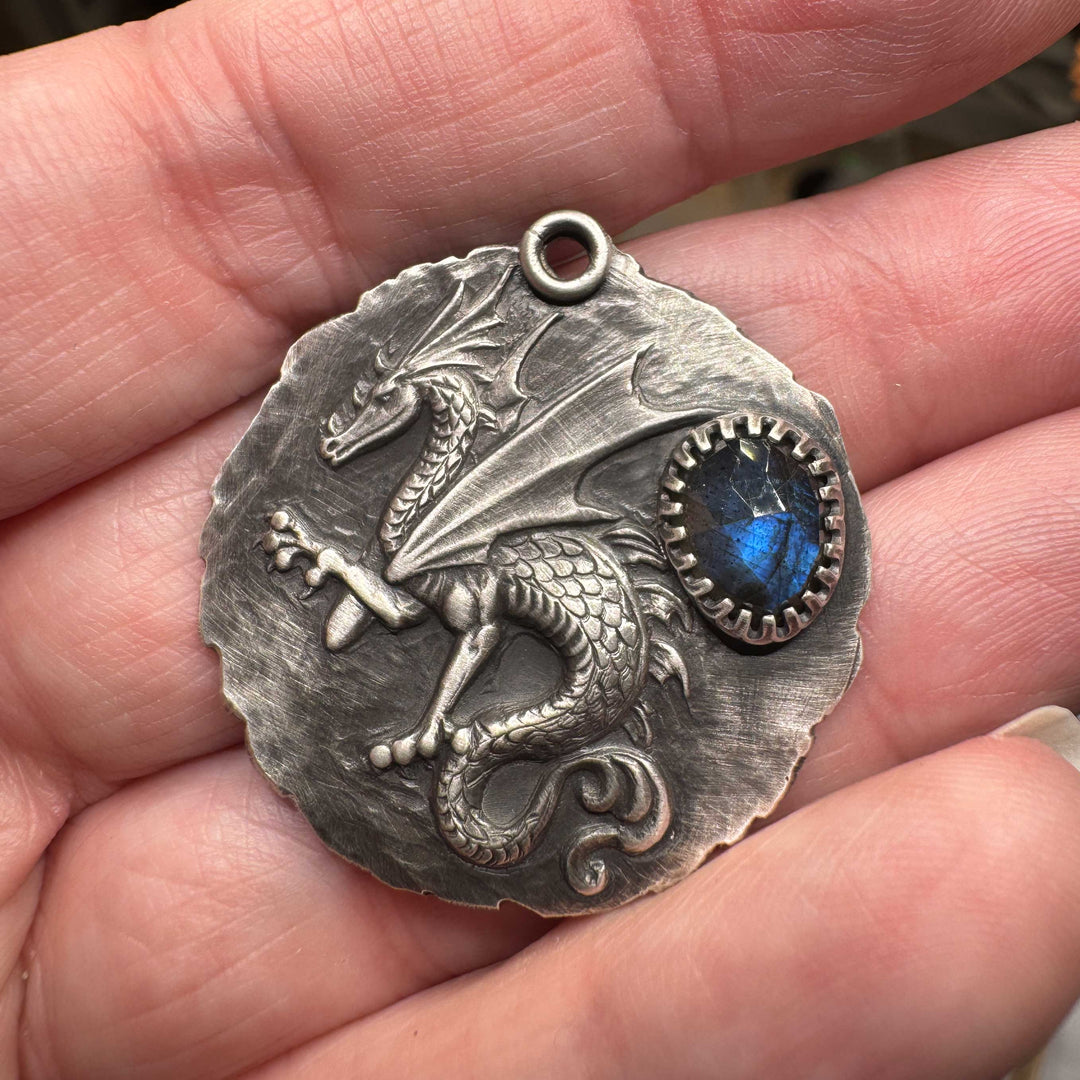 Sculptural dragon in raised relief on a hand-textured sterling silver medallion