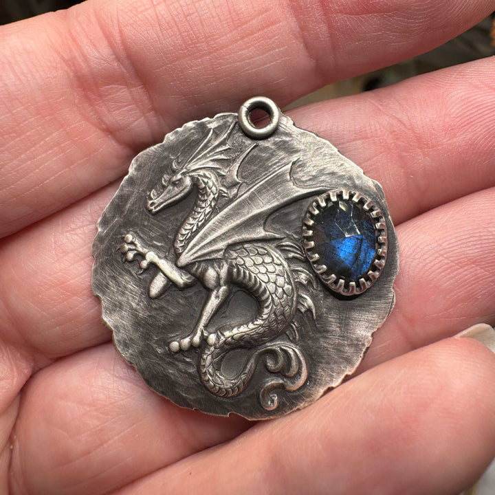 Sculptural dragon in raised relief on a hand-textured sterling silver medallion
