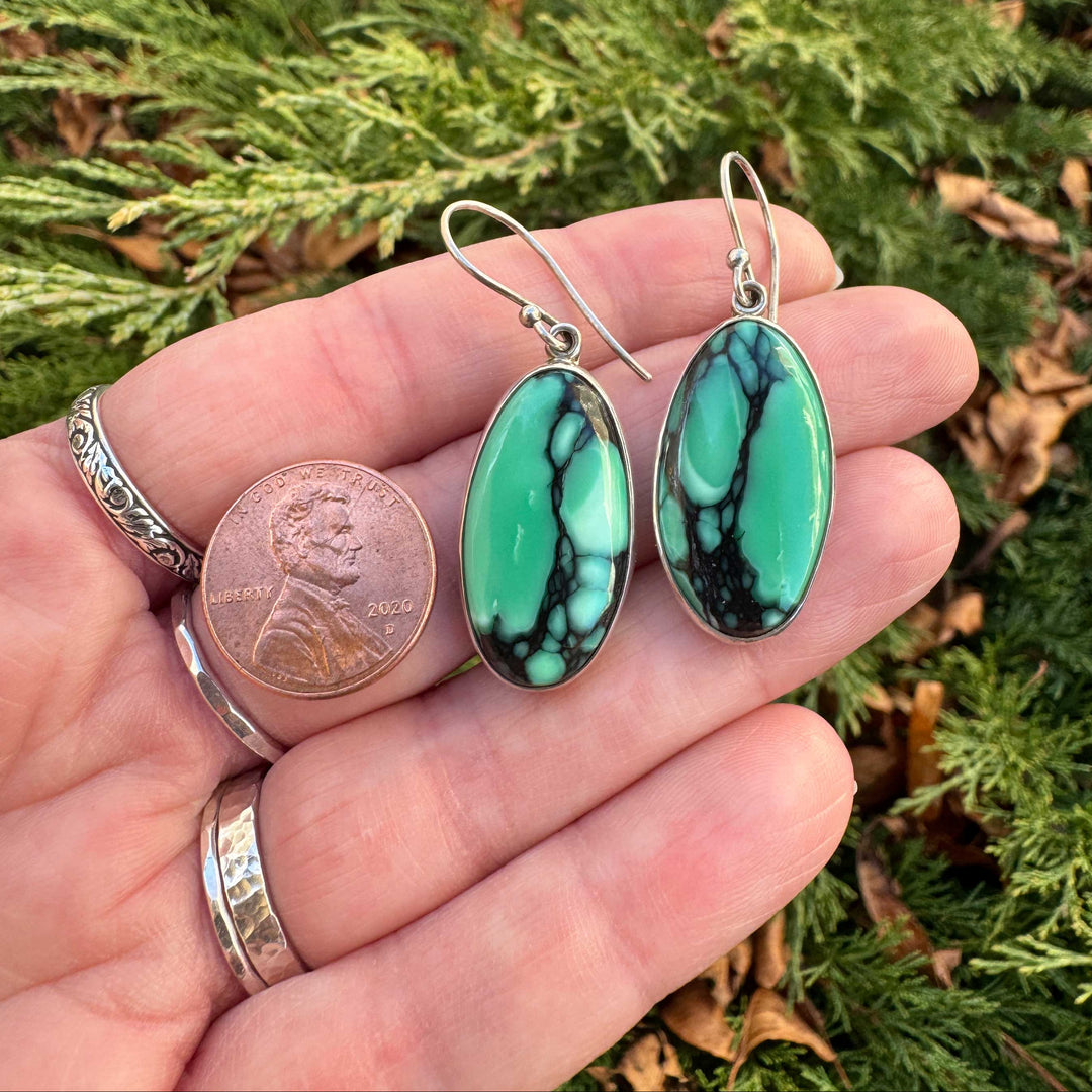 Emerald Rose variscite dangle earrings in sterling silver shown in hand for size comparison.