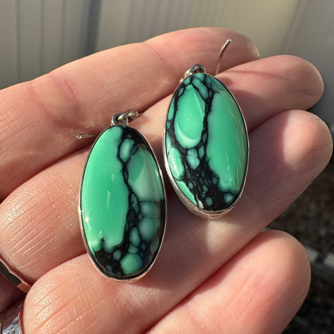 Close-up of Emerald Rose variscite earrings showing vibrant green stones with black matrix.