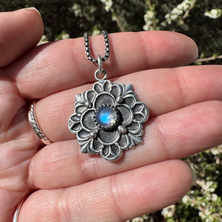 Sterling silver floral pendant with magical blue flash moonstone and intricate metalwork