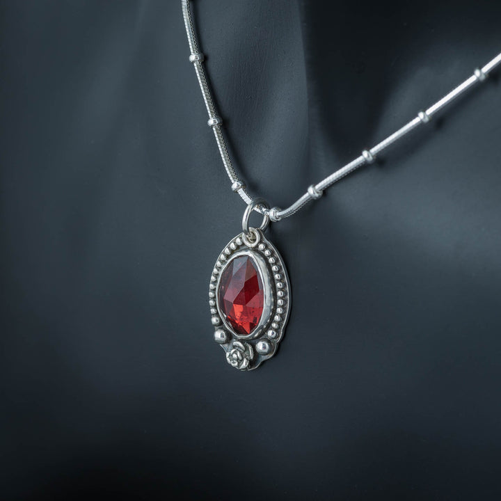 Handcrafted gothic necklace with a garnet flower pendant.