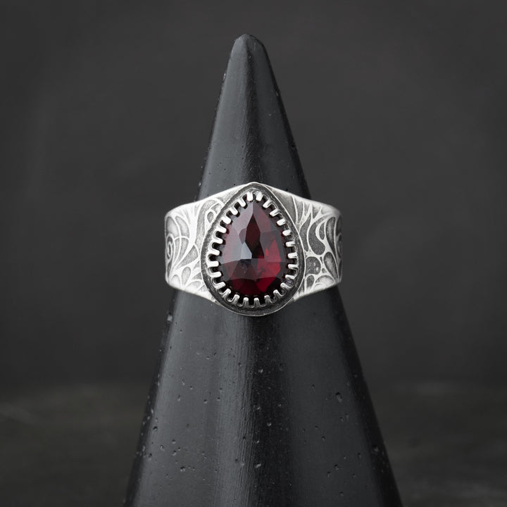 Handcrafted gothic ring with a rose motif and garnet stone. Handcrafted in Fort Collins, Colorado.