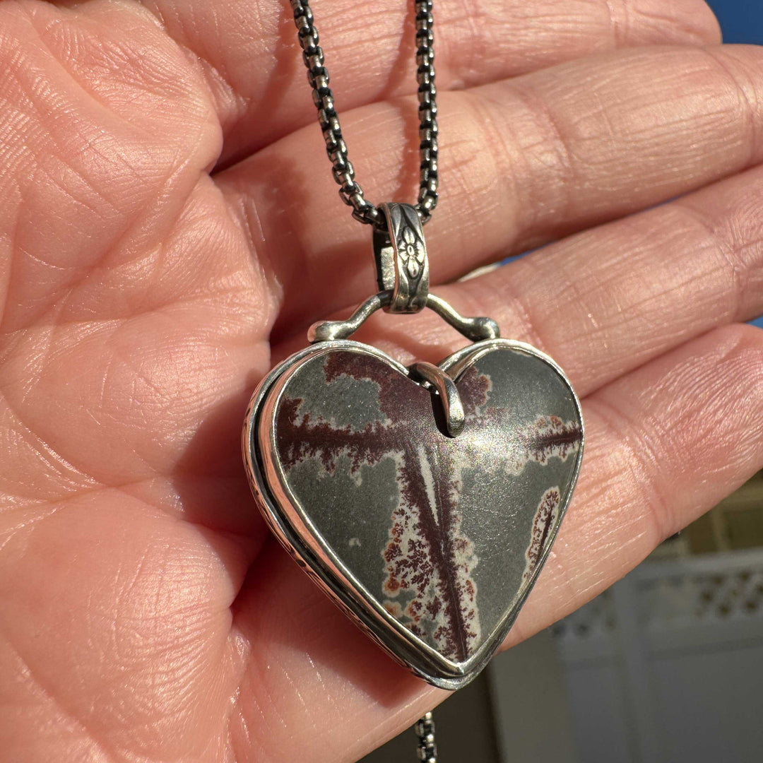 One of a kind dendritic rhyolite heart pendant with natural inclusions in full sunlight