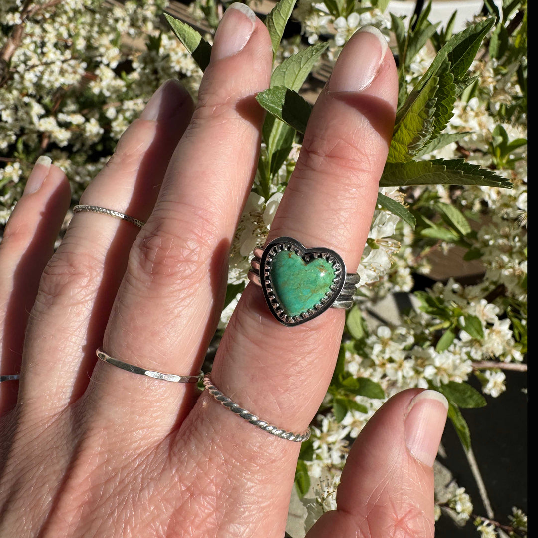 Detailed view of blue-green Sonora turquoise heart cabochon with rust inclusions in handcrafted silver setting, size 7