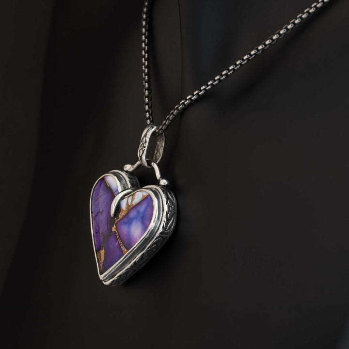Heart-shaped pendant with purple stone on a black background