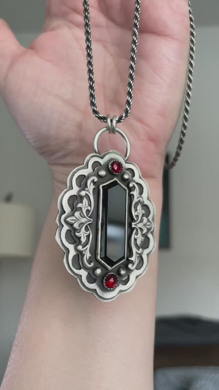 Video showing a gothic vampire statement necklace in sterling silver with black onyx and garnet, highlighting dimensional silverwork, weight, and light movement