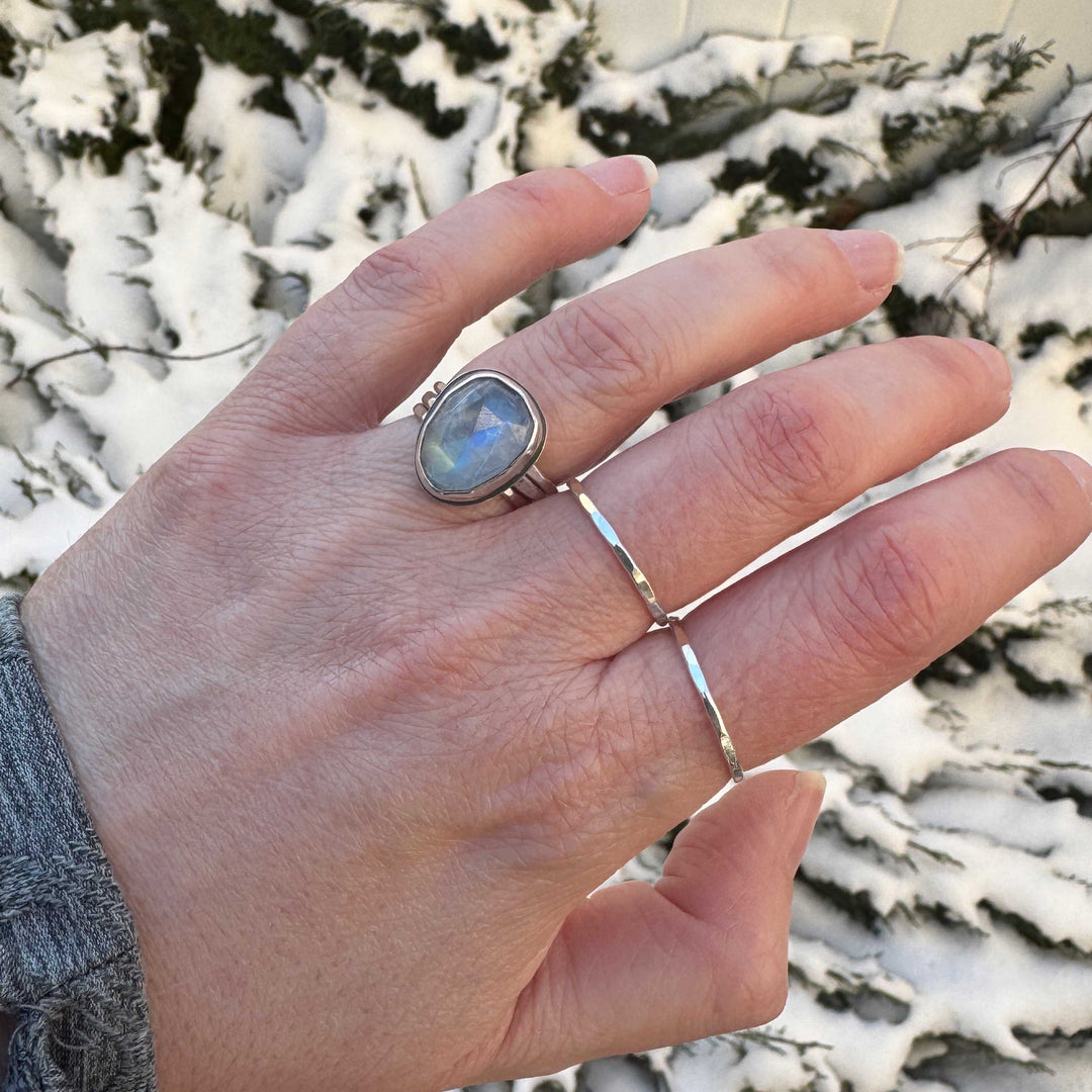 Handmade rose cut rainbow moonstone ring size 6.5 worn on hand outdoors with hammered stacker rings