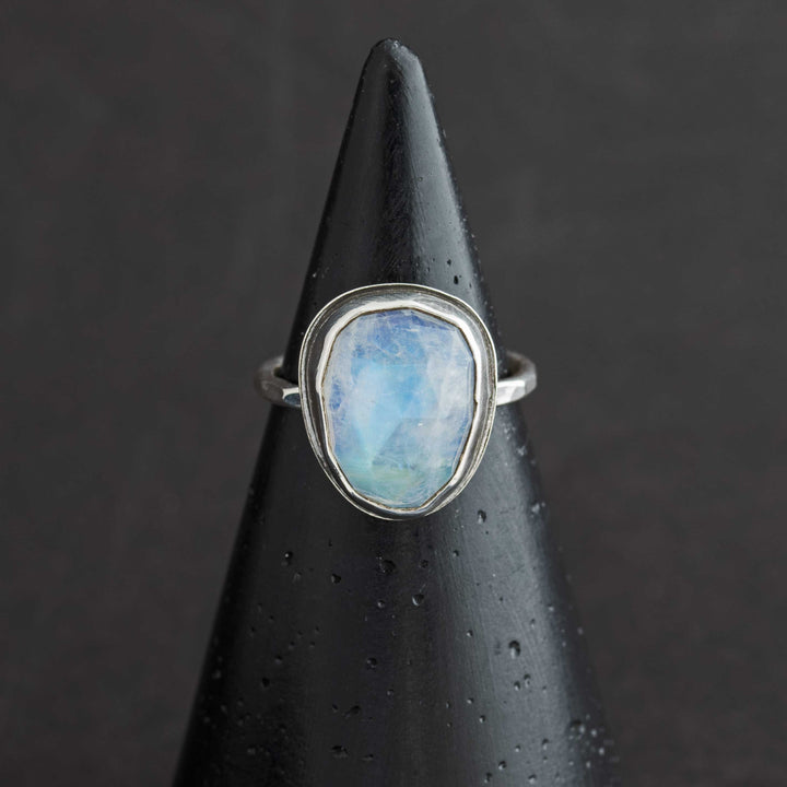 Handmade rose cut rainbow moonstone ring size 6.5 in sterling silver bezel, front view on cone display