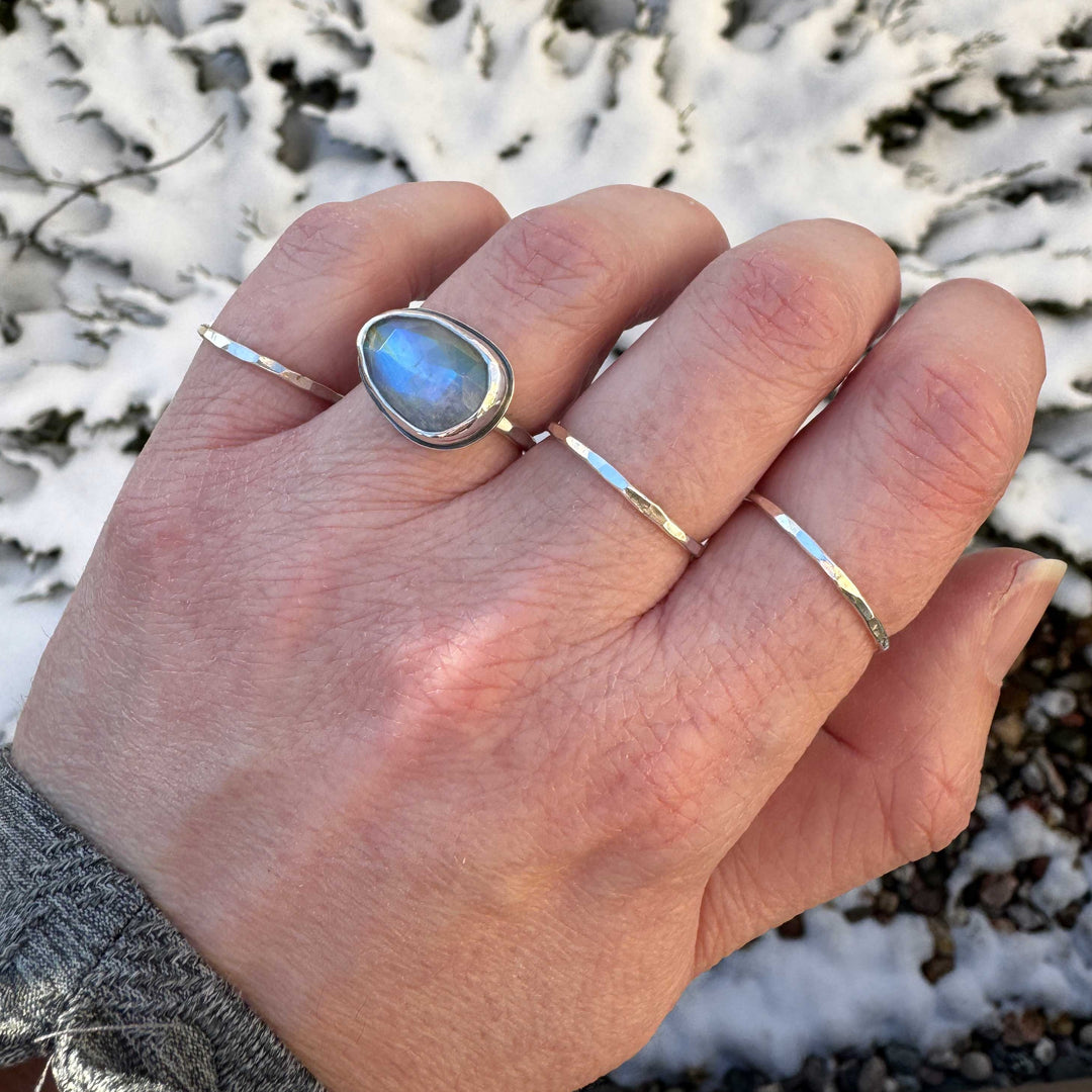 Rose cut rainbow moonstone ring size 6 with stacker bands, vivid blue flash visible, winter outdoor setting