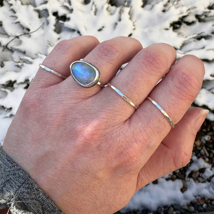 Rose cut rainbow moonstone ring size 6 with stacker bands, vivid blue flash visible, winter outdoor setting