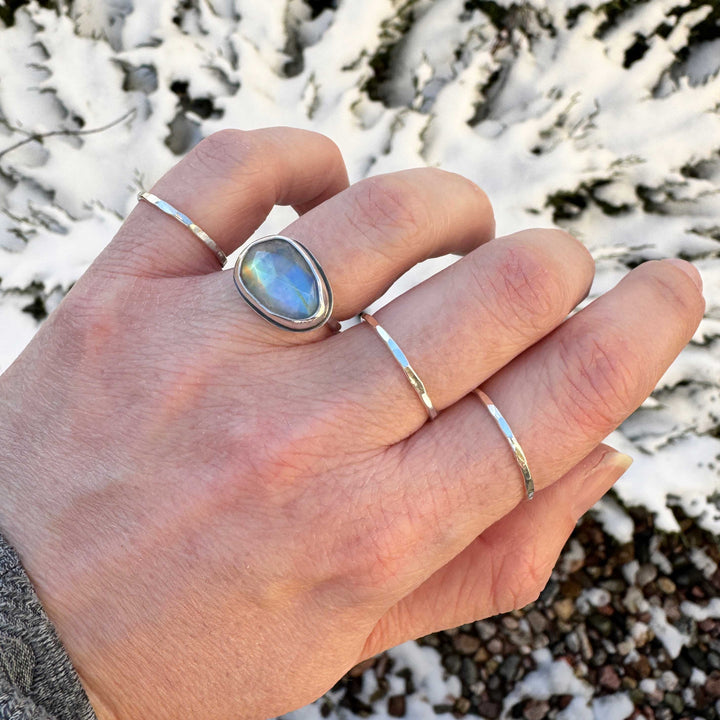 Rose cut rainbow moonstone ring size 6 on hand, blue and gold flash, snowy evergreen background