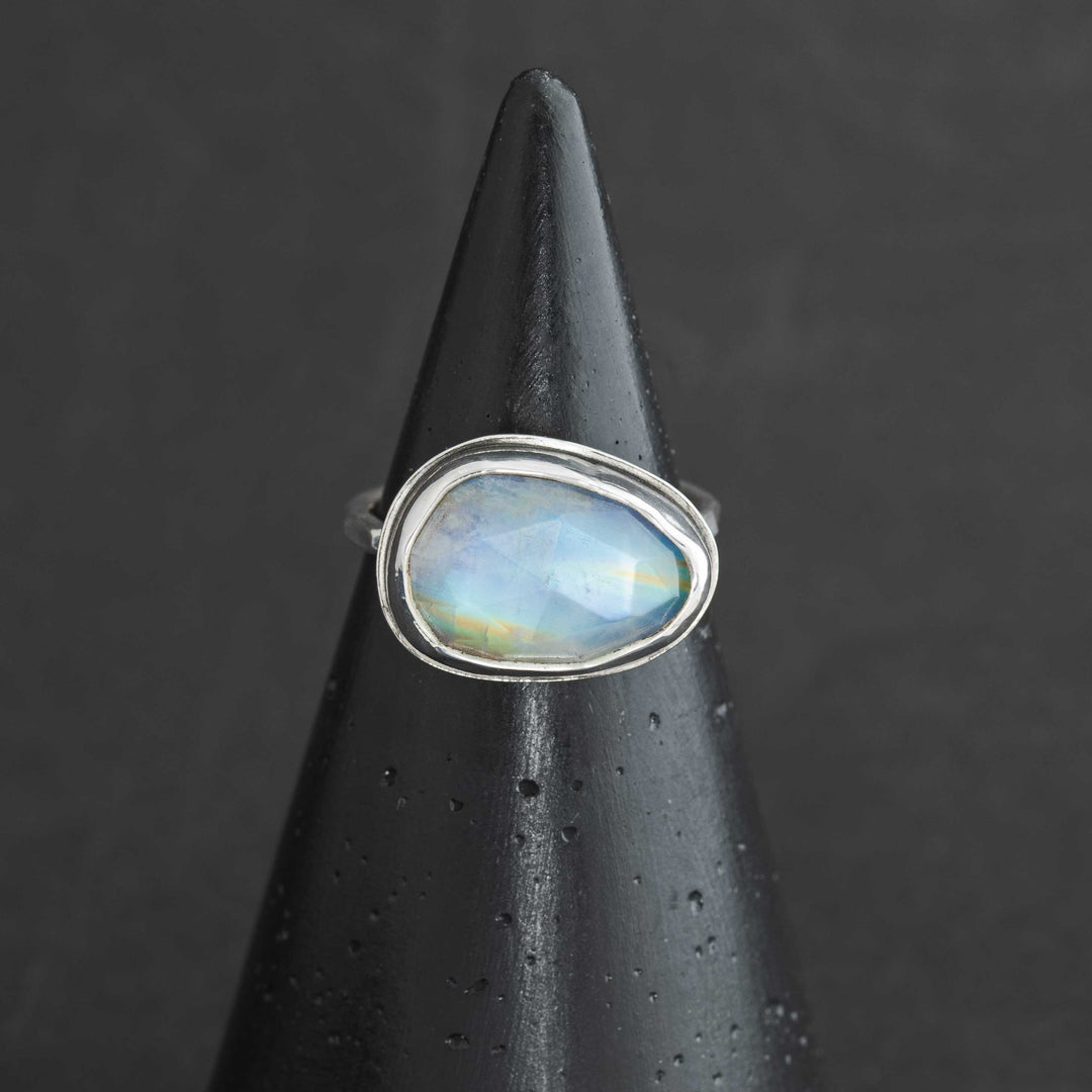 Handmade rose cut rainbow moonstone ring size 6 in sterling silver bezel, front view on cone display
