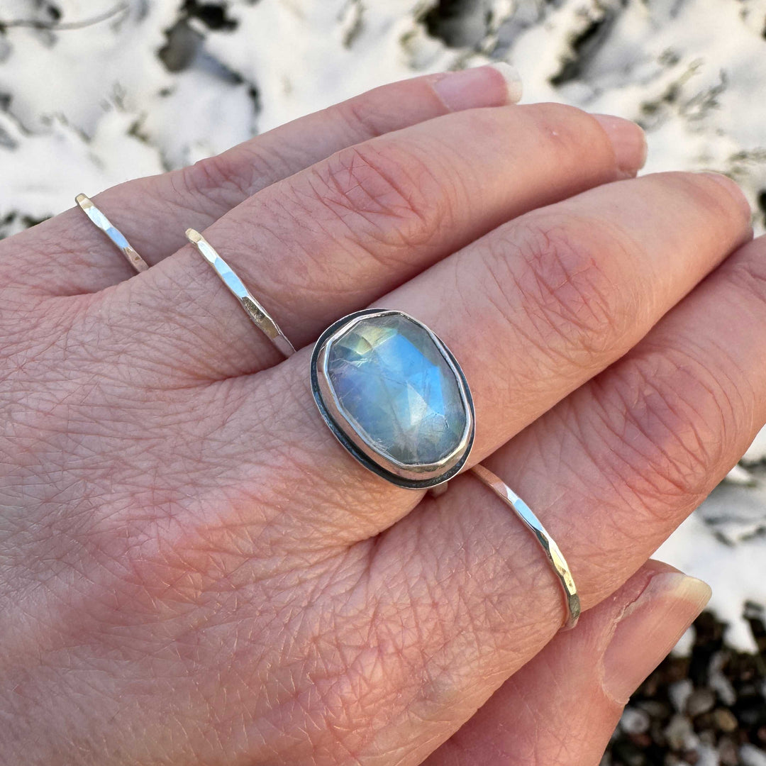 Rose cut rainbow moonstone ring size 7.5 on hand with stacker bands, blue and gold flash visible, winter setting