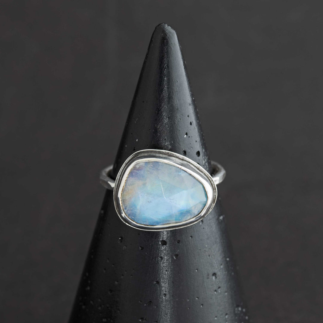 Handmade rose cut rainbow moonstone ring in sterling silver bezel, front view on cone display