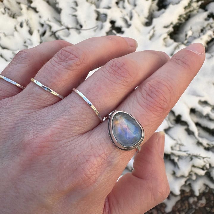 Rose cut rainbow moonstone ring size 9.5 on hand with stacker bands, blue-purple and sunset orange flash, winter outdoor setting