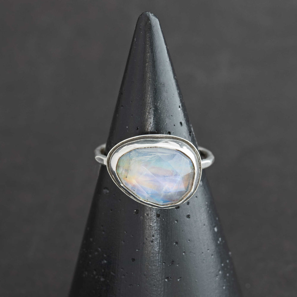 Handmade rose cut rainbow moonstone ring size 9.5 in sterling silver bezel, front view on cone display
