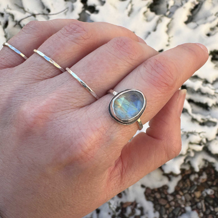 Rose cut rainbow moonstone ring size 9 on hand with stacker bands, blue and yellow-gold flash, winter outdoor setting