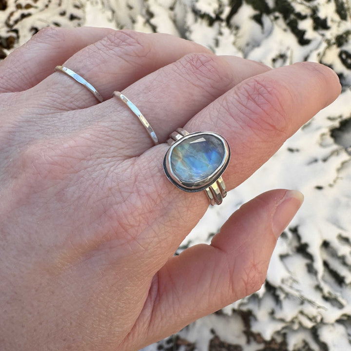 Handmade rose cut rainbow moonstone ring size 9 worn on hand outdoors with hammered stacker rings, strong blue flash