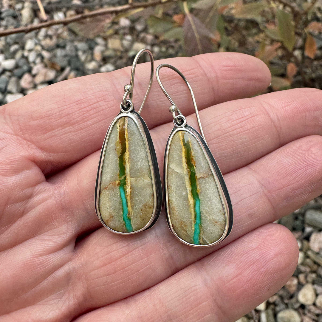 Handcrafted Royston Ribbon turquoise dangle earrings photographed in natural light, emphasizing turquoise ribbon and desert tones.