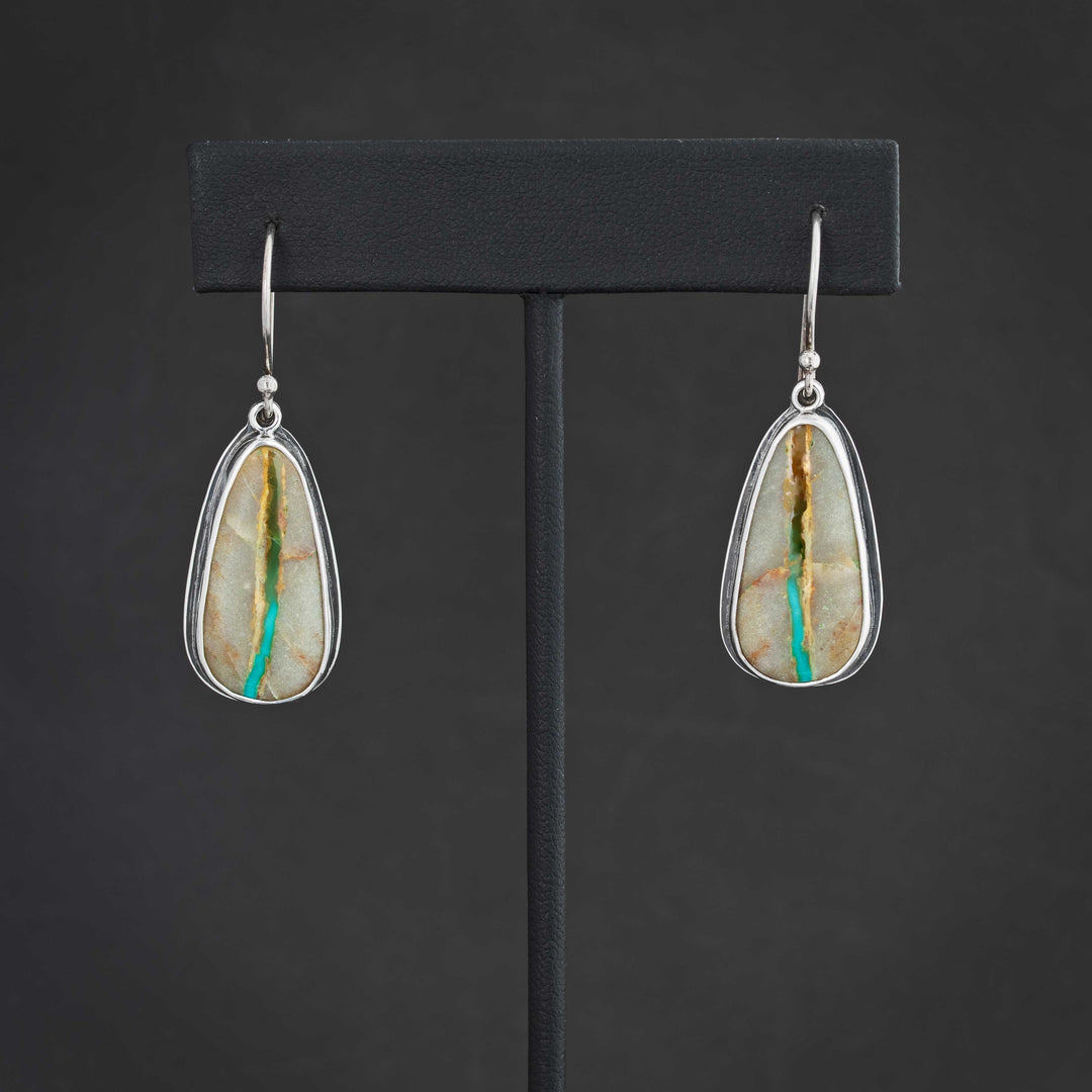 Front view of handmade Royston Ribbon turquoise dangle earrings in sterling silver, showing natural turquoise ribbon pattern and teardrop shape.