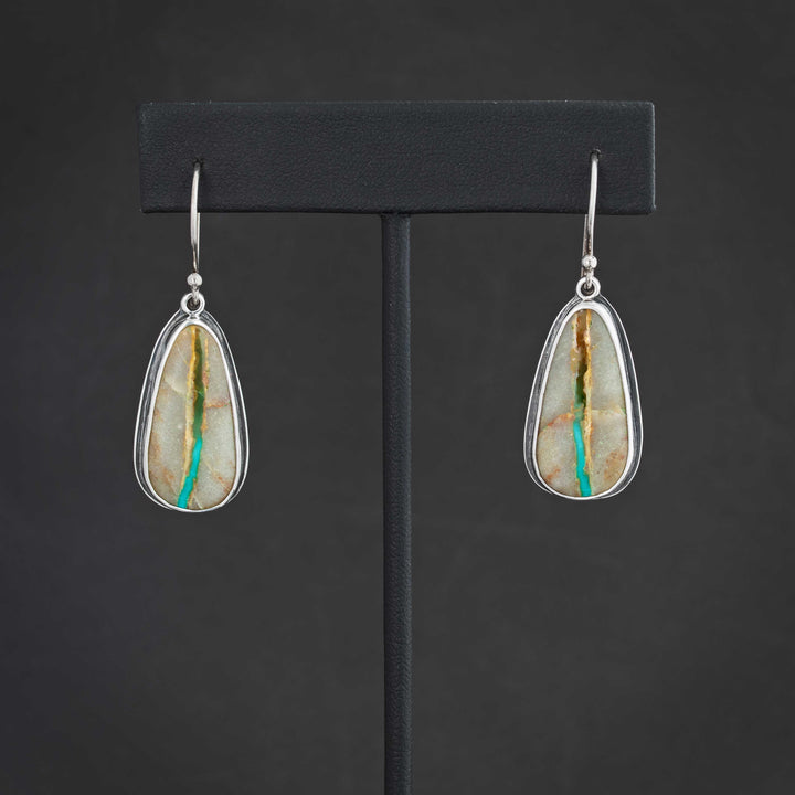 Front view of handmade Royston Ribbon turquoise dangle earrings in sterling silver, showing natural turquoise ribbon pattern and teardrop shape.