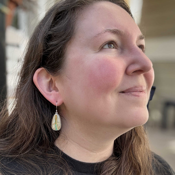 Royston Ribbon turquoise dangle earrings in sterling silver shown worn, highlighting natural turquoise ribbon pattern and artisan craftsmanship by Silverthaw Jewelry.