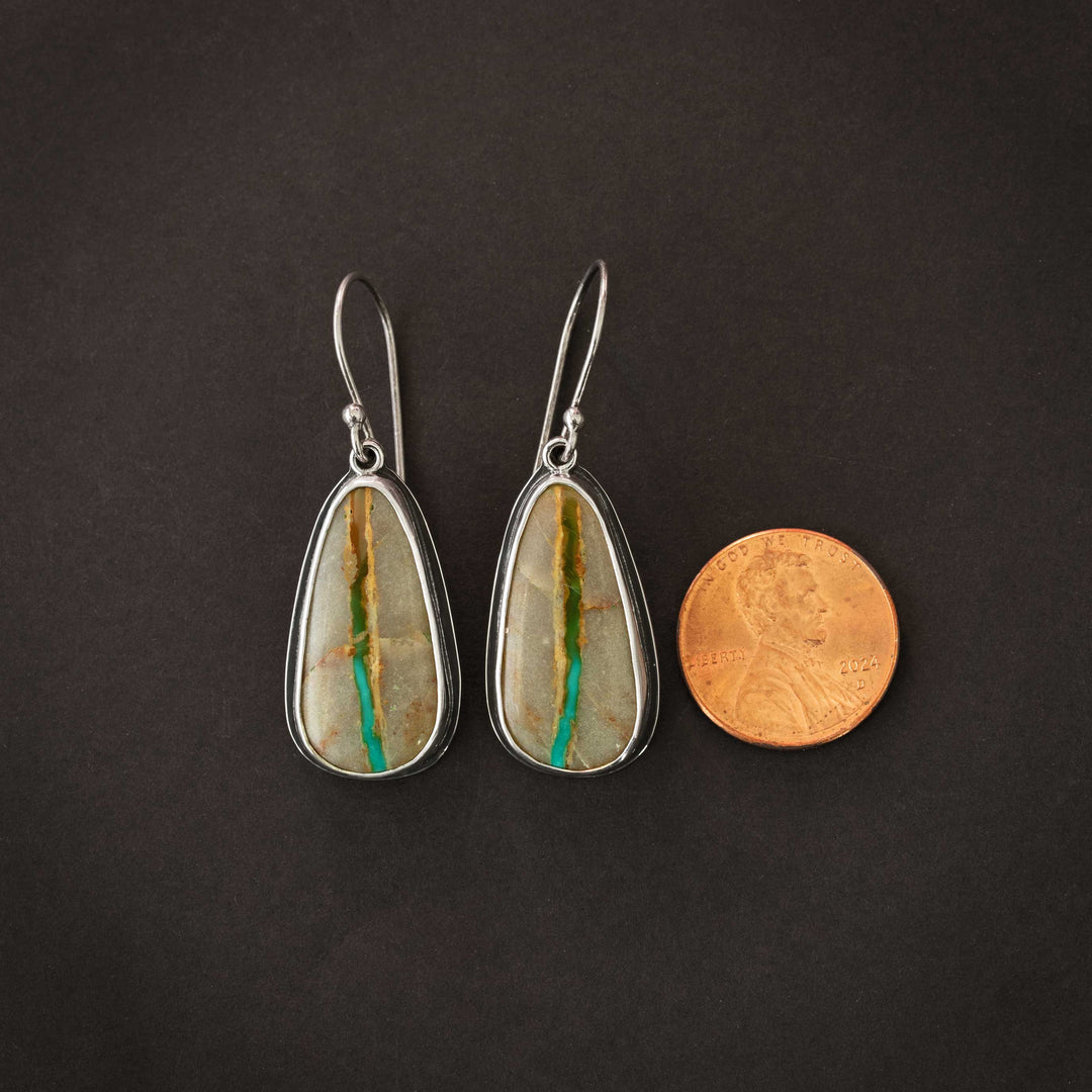 Pair of Royston Ribbon turquoise earrings beside a penny for size reference, showing natural turquoise ribbon pattern.