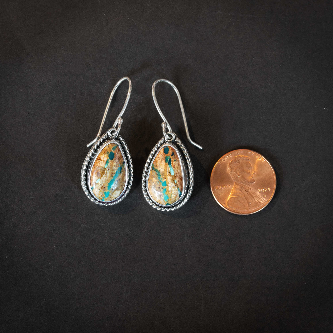 Royston Ribbon turquoise earrings beside a penny for scale, handmade sterling silver with earthy turquoise ribbon stones.