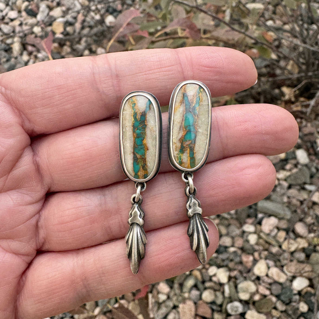 Close-up of Royston Ribbon turquoise earrings with golden host rock and vivid turquoise veins.