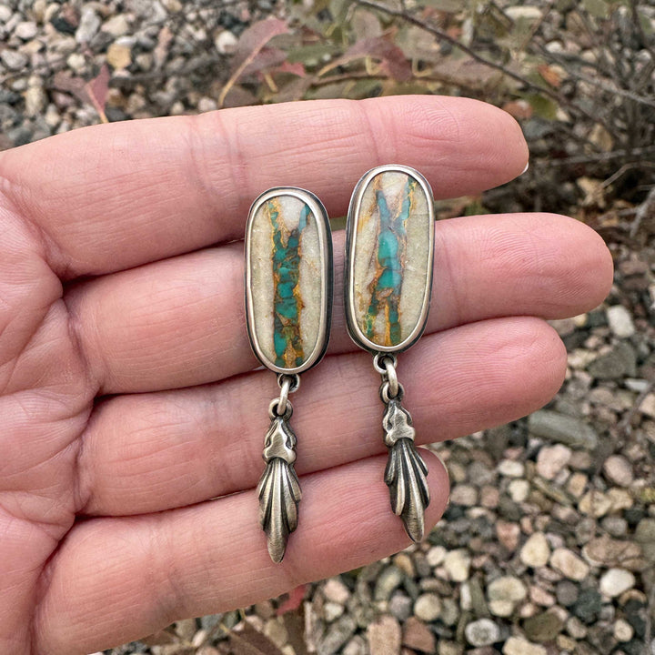 Close-up of Royston Ribbon turquoise earrings with golden host rock and vivid turquoise veins.