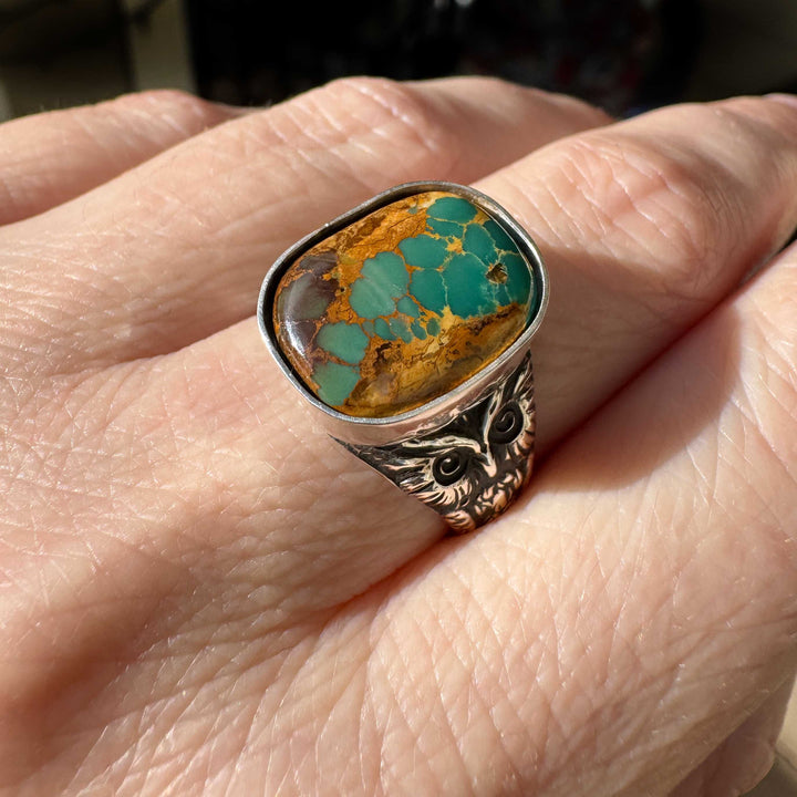 Handmade Royston Ribbon turquoise owl ring photographed in natural light, showing detailed silver owl design and natural turquoise ribbon pattern.