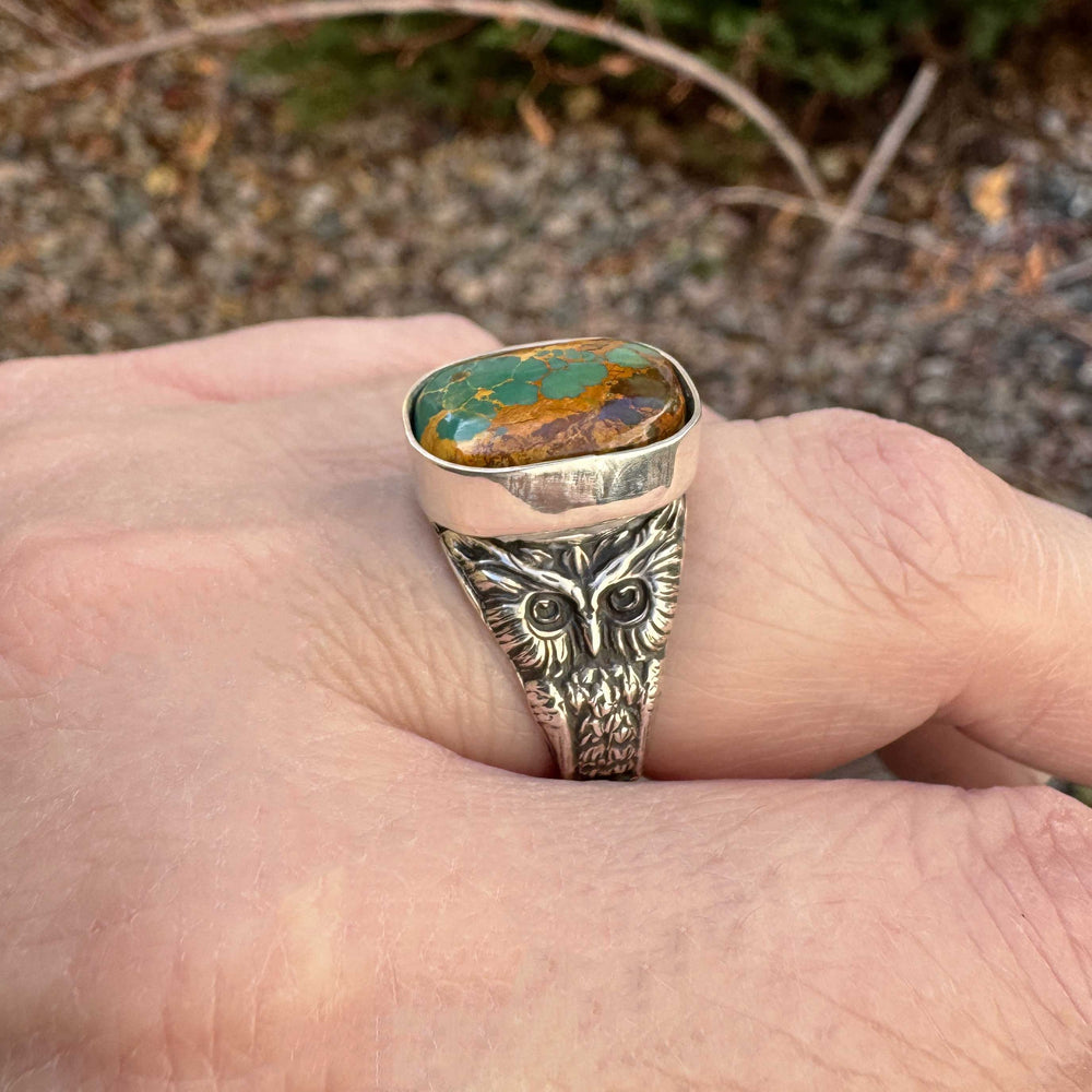 Close-up of Royston Ribbon turquoise owl ring, highlighting intricate sterling silver owl motif and earthy turquoise gemstone with ribbon veining.